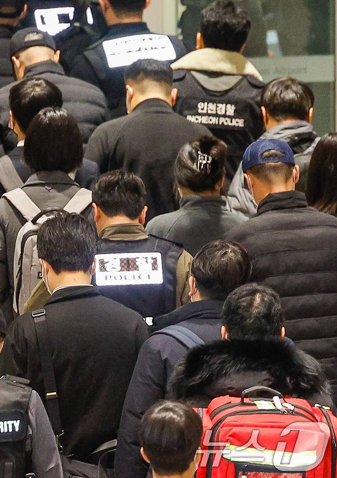 캄보디아를 거점으로 대규모 스캠(사기) 범죄 등을 저질른 한국 국적 피의자 73명이 강제 송환된 23일 오전 9시 36분 인천국제공항 2터미널에서 120억 원대 로맨스 스캠 범죄 총책 부부가 경찰에 붙잡혀 이송되고 있다. 2026.1.23/뉴스1 ⓒ News1 안은나 기자