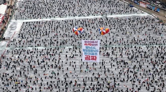 지난 11일 강원도 화천군 ‘산천어 축제’ 현장을 공중에서 내려다본 모습. 전국에서 온 낚시객들이 꽁꽁 언 화천천에 구멍을 뚫고 얼음 낚시를 즐기고 있다. 이날 6만1324명이 현장을 찾았다./화천군 제공