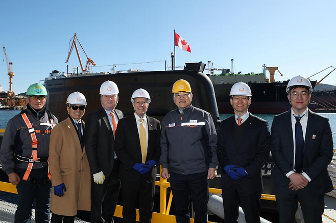 빅터 피델리(왼쪽 네 번째) 캐나다 온타리오주 경제개발부 장관이 22일 한화오션 거제사업장에서 김희철(오른쪽 세 번째) 한화오션 대표 등과 함께 한국의 최신형 잠수함 장영실함을 배경으로 기념 촬영을 하고 있다. 한화오션 제공