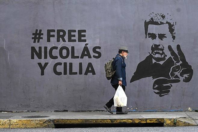 2026년 1월17일 베네수엘라 수도 카라카스의 거리에서 한 남성이 니콜라스 마두로 대통령 부부의 석방을 촉구하는 벽화 옆을 지나고 있다. AFP 연합뉴스