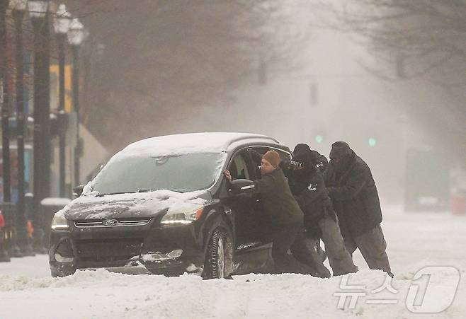 25일(현지시간) 미국 전역에 걸쳐 겨울 폭풍이 몰아친 가운데, 켄터키주 루이빌의 한 도로에서 남성들이 눈에 갇힌 차량을 빼내려 안간힘을 쓰고 있다. 2026.01.25. ⓒ 로이터=뉴스1 ⓒ News1 류정민 특파원