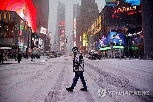 눈 내린 뉴욕 타임스퀘어 (로이터=연합뉴스) 25일(현지시간) 눈폭풍 영향권에 든 미국 뉴욕 타임스퀘어 광장을 한 시민이 걷고 있다. 2026.1.25