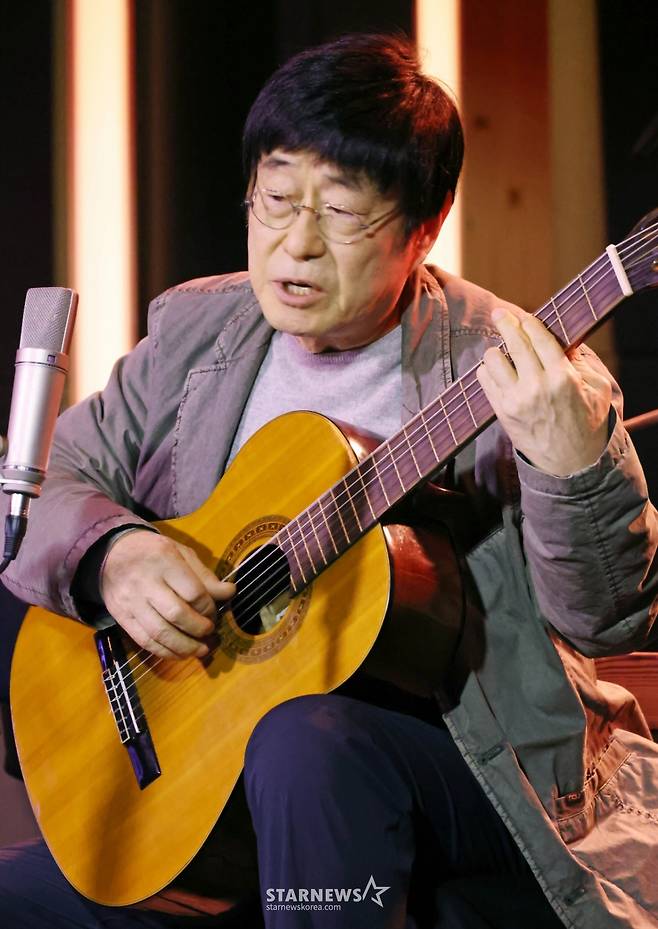 가수 김창완이 27일 오후 서울 종로구 팡타캐라지에서 진행된 싱글 'Seventy' 발매 기자간담회에서 참석자들에게 노래선물을 하고 있다. 이번 싱글에는 'Seventy'와 유쾌한 정서의 팝록 '사랑해'가 수록됐다. /2026.01.27 /사진=이동훈 photoguy@