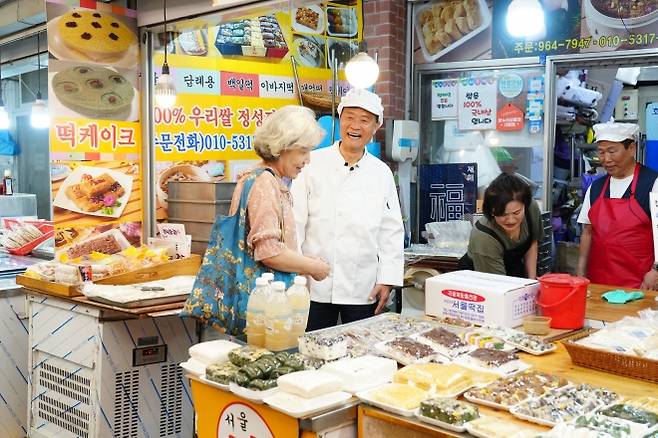 골목상권 활성화를 위해 돌곶이시장 일일 상인으로 변신한 이승로(가운데) 성북구청장이 지난해 5월 시장을 찾은 주민에게 성북사랑상품권을 설명하고 있다. 성북구 제공