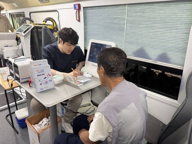 '달성건강빵빵이' 현장에서 의료진이 주민에게 혈액검사 결과를 설명하는 모습. 달성군 제공