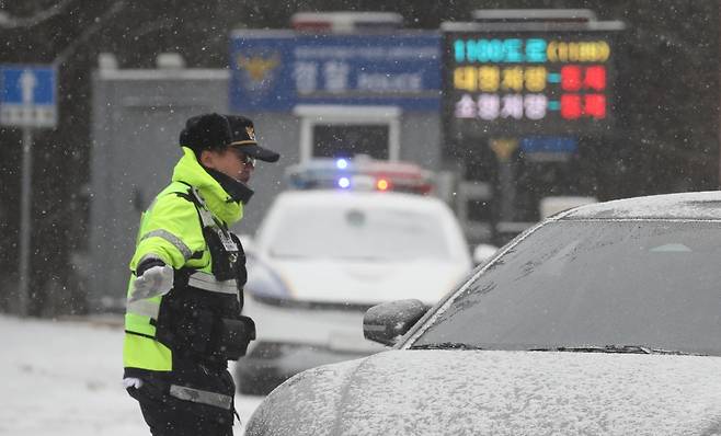 제주도에 대설특보가 내려진 지난달 11일 오전 제주시 어승생 삼거리 입구에서 제주서부경찰서 소속 경찰관이 도로통제를 하고 있다./사진=뉴시스.