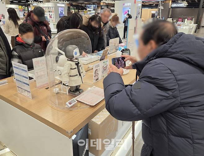 이마트 로봇 매장에서 한 고령의 고객이 감정 표현이 가능한 반려로봇을 촬영하고 있다. (사진=한전진 기자)