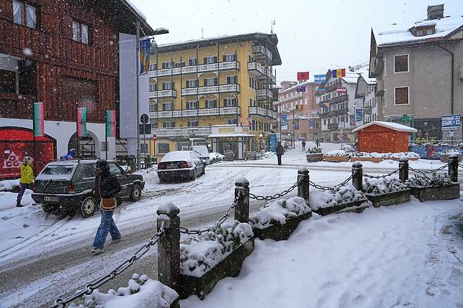 이탈리아 코르티나 담페초에서 2026 밀라노-코르티나 동계올림픽을 앞두고 눈이 내리는 가운데 사람들이 도심 쇼핑 거리를 걷고 있다. /AP 연합뉴스