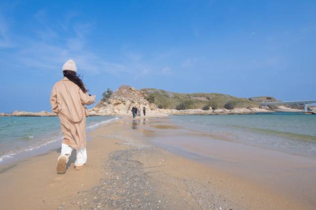 ▲ 5일 동해안의 홍해로 불리는 고성군 송지호 대섬까지 모래톱이 연결돼 관광객들이 바다 위로 걸어가고 있다. 김주현 기자