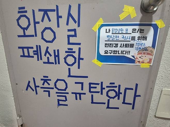 2026년 2월4일 서울 마포구 동물입양센터 아름품의 2층 화장실 문 앞. 사쪽이 화장실을 용접으로 막자 연대 시민이 항의하는 문구를 마스킹테이프로 붙였다. 신다은 기자