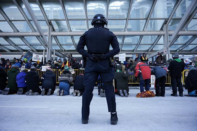 1월23일 미니애폴리스 국제공항 1터미널 입구 주변에 모인 성직자들이 아스팔트 위에서 무릎 꿇은 채 기도하고 있다. ⓒREUTERS