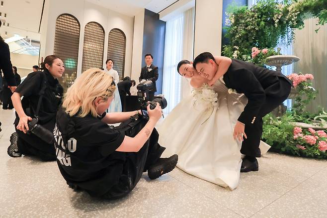 메크투 고소연 팀장의 디렉션에 맞춰 신랑 신부가 웨딩홀 로비에서 포즈를 취하고 있다. / 고운호 기자