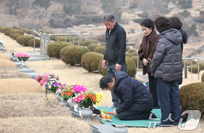 설 연휴를 하루 앞둔 13일 경기 용인시 처인구 천주교용인공원묘원에서 성묘객들이 가족의 묘를 찾아 성묘를 하고 있다. 2026.2.13 ⓒ 뉴스1 김영운 기자