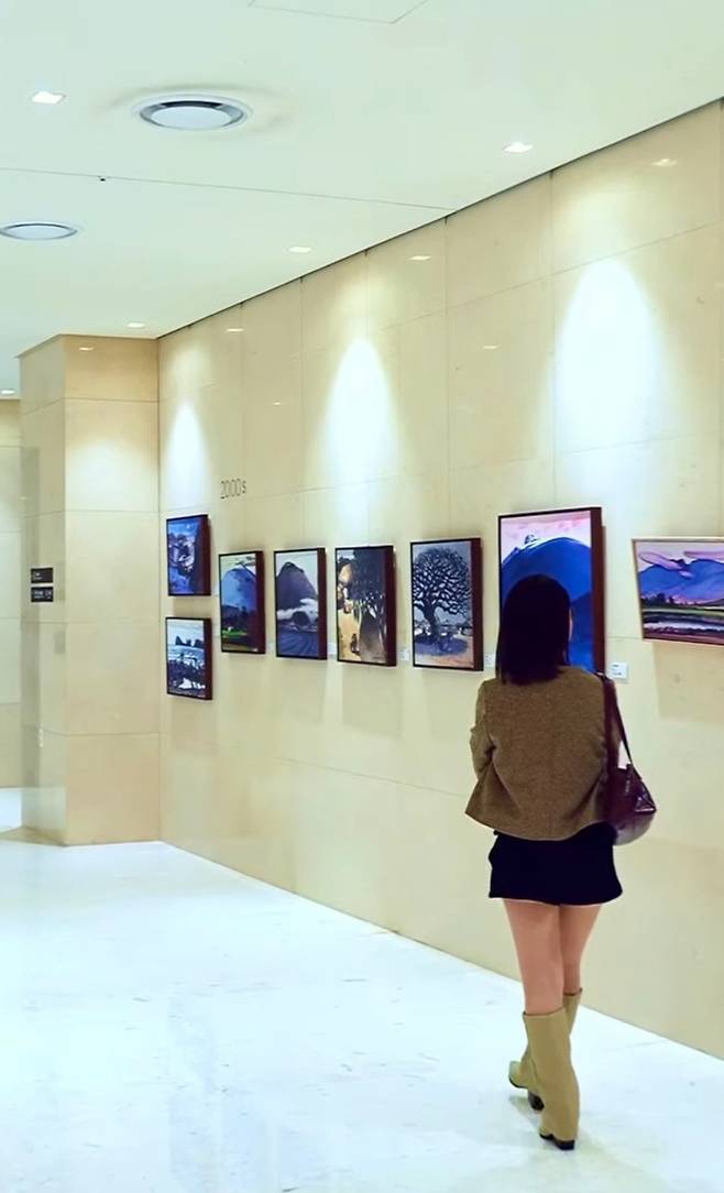 제주신화월드 ‘JSW 컬처 존’에 전시된 김택화 화백 작품을 관람하는 모습. (제주신화월드 SNS)