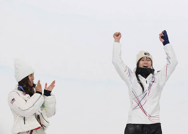 12일(현지시간) 이탈리아 리비뇨 스노파크에서 열린 2026 밀라노-코르티나담페초 동계올림픽 스노보드 여자 하프파이프 결승에서 금메달을 따낸 최가온이 시상대에 오르며 기뻐하고 있다. 왼쪽은 은메달을 딴 미국 클로이 김. 연합뉴스