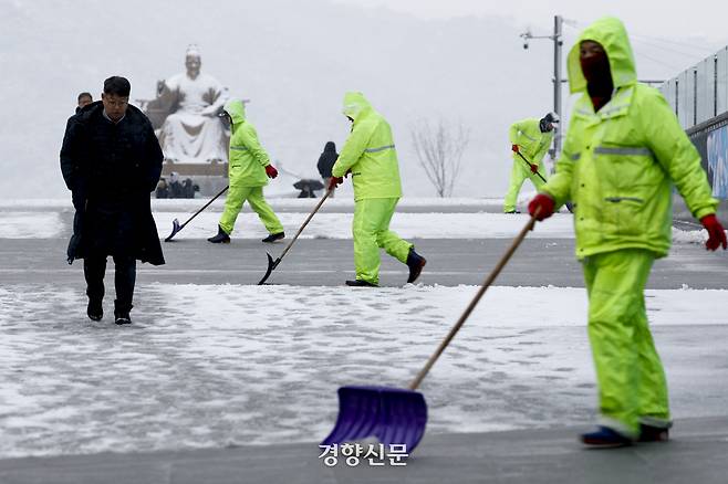 갑작스러운 폭설이 내린 지난 6일 시민들이 눈을 맞으며 서울 세종로 사거리 인근을 지나고 있다. 문재원 기자