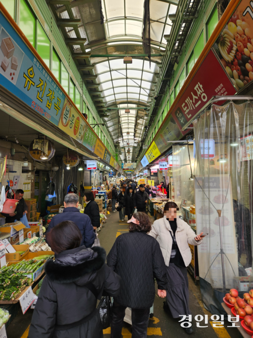 설 명절을 앞둔 12일 광명전통시장을 찾은 시민들이 좁은 시장 통로를 따라 오가고 있다.2026.2.12 /김지원기자 zone@kyeongin.com