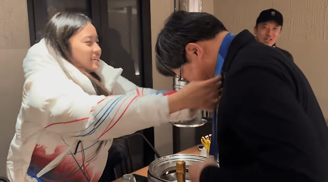 올림픽 설상 종목에서 한국 선수 최초로 챔피언에 오른 17세 3개월 최가온이 자신의 금메달을 구동회 대표에게 걸어주고 있다.