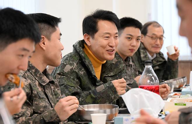 오세훈 서울시장이 국군 장병들과 함께 식사하며 대화하고 있는 사진이다. 오세훈 시장은 밝은 표정으로 장병들을 바라보고 있다.