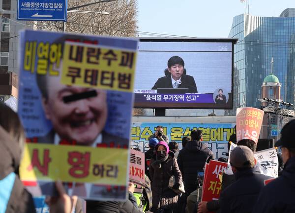 촛불행동 관계자들이 19일 서울중앙지법 인근에서 12·3 비상계엄과 관련해 내란 우두머리 혐의로 기소된 윤석열 전 대통령에 대한 1심 선고 생중계를 시청하고 있다. 이날 재판부는 윤 전 대통령에게 무기징역을 선고했다. 2026.2.19 연합뉴스