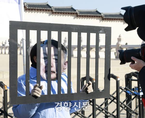 윤석열 내란 우두머리 혐의 1심 선고일인 19일 서울 광화문 앞에서 전국민중행동 소속 활동가들이 법정 최고형 선고를 촉구하며 퍼포먼스를 벌이고 있다. 문재원 기자