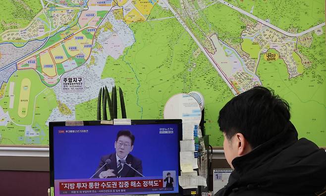 지난달 21일 서울 서초구 한 부동산 중개업소에서 한 시민이 이재명 대통령의 신년 기자회견 방송 중 부동산 정책 관련 발표를 지켜보고 있다. 연합뉴스