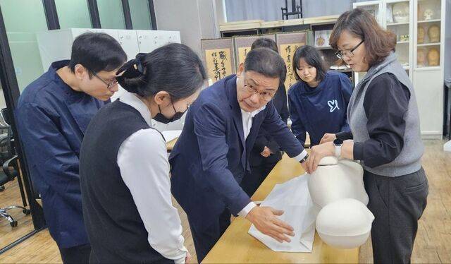 이종행(가운데) 장례지도사가 지난 9일 서울 영등포구 엔딩라이프장례지도사교육원에서 수강생들을 상대로 마네킹에 지옷을 입히는 시범을 보이고 있다.