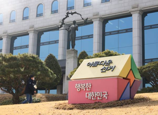 22일 과천 중앙선거관리위원회에서 시민이 선관위 간판 앞을 지나고 있다. 전국에서 6월 3일 동시에 실시되는 제9대 지방선거가 23일로 100일 앞으로 다가왔다. 최대 10여곳의 국회의원 재·보궐선거와 같이 치러지는 이번 지방선거는 작년 6월 이재명 정부가 출범한 이후 처음 진행되는 전국 단위 선거로 이재명 정부에 대한 중간 평가 성격이자 2028년 총선과 2030년 대선으로 이어지는 향후 정국의 향배를 보여줄 풍향계가 될 전망이다. /연합뉴스