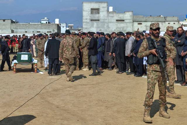 22일 파키스탄 북서부 카이버파크툰크주 반누 지역에서 발생한 자살폭탄 테러로 숨진 군 장교의 장례식에 군 관계자들이 참석한 가운데 한 군인이 경계 근무를 서고 있다. 반누=AP 연합뉴스