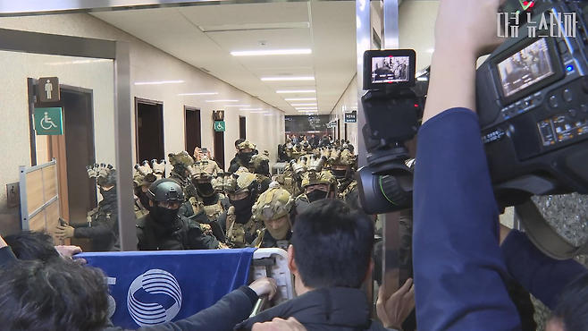 2024년 12월 3일 윤석열의 비상계엄 선포 이후, 국회 건물 안으로 침입한 계엄군과 시민들이 대치하고 있는 모습.