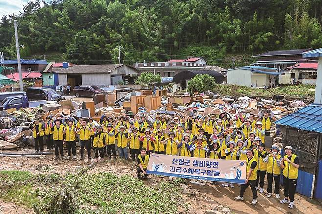 지난해 7월 경남권 일대 하나님의 교회 신자들이 산청군 수해복구 활동을 펼치며 구슬땀을 흘렸다. 봉사자들 뒤에 집 밖으로 꺼내진 장롱과 냉장고, 식탁, 장판 등 가재도구와 생필품이 쌓여 있다.