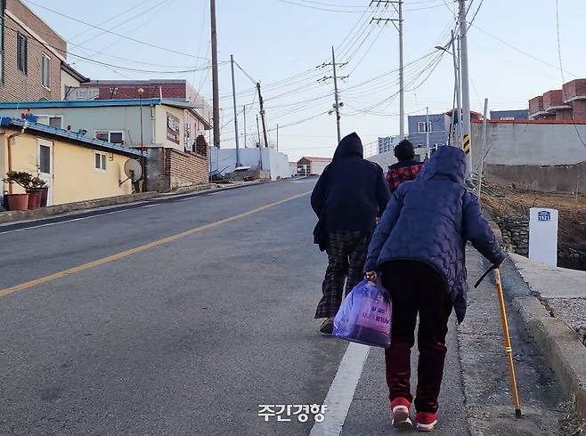 석리마을 주민들이 언덕 위에 있는 임시 주거용 조립주택 단지로 걸어가고 있다. 이재덕 기자