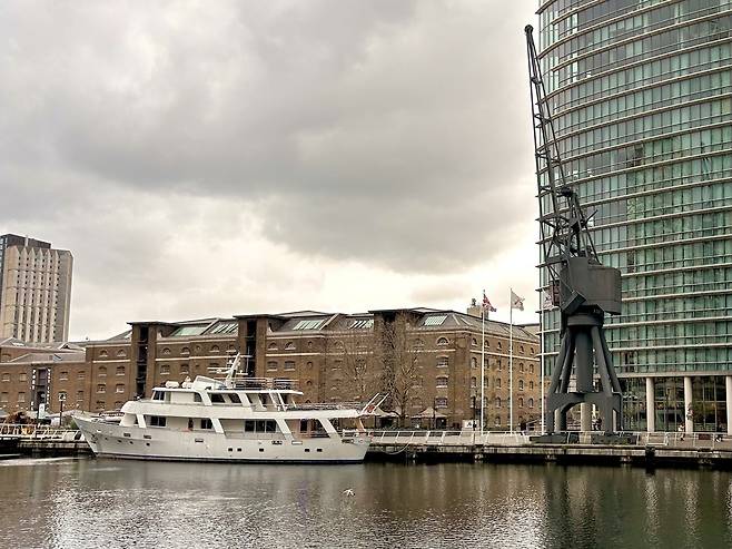 ▲ 지난 23일(현지시각) 영국 런던 동부 도크랜드 지역의 카나리 워프(Canary Wharf) 운하에 있는 항만 크레인과 요트.