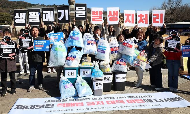 25일 오전 서울 종로구 청와대 분수대 앞에서 열린 ‘수도권 쓰레기 타 지역 반출 실태 고발 및 대통령 대책 촉구 기자회견’ 참가자들이 서울시 자치구 종량제 쓰레기 봉투를 각 지역 이름이 적힌 쓰레기통에 버리는 행위극을 하고 있다. 최현수 기자 emd@hani.co.kr