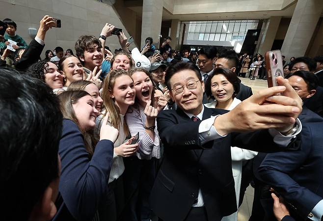 이재명 대통령과 김혜경 여사가 26일 서울 용산구 국립중앙박물관에서 열린 특별전 ‘우리들의 이순신’을 관람한 뒤 외국인 관광객들과 기념촬영을 하고 있다. 뉴스1