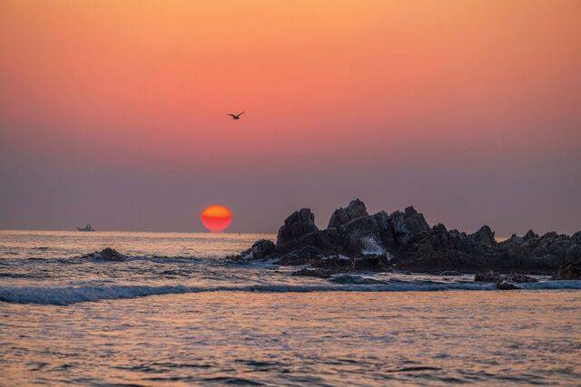 강원도 양양군 현북면 기사문 해변 앞 삼형제바위 옆으로 오메가(Ω) 모양의 붉은 해가 솟아오르고 있다.