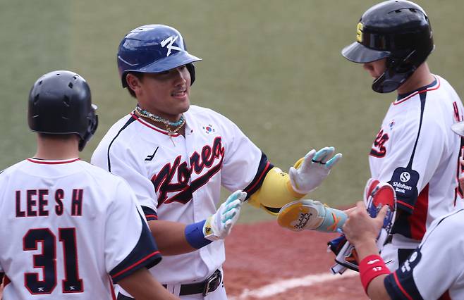 WBC 대표팀 안현민이 26일 일본 오키나와 가데나 구장에서 열린 삼성과 연습경기 5회말 만루홈런을 때린 뒤 동료들과 하이파이브하고 있다. 연합뉴스