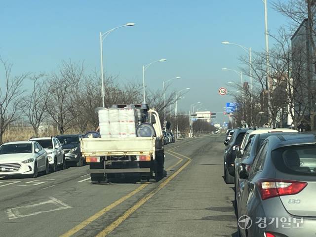 시흥 시화공단 엠티브이북로 불법주차가 상습화되면서 대형 교통사고 발생이 우려되고 있다. 화물차량이 불법 주차된 차량들을 피해 중앙선을 침범, 역주행하고 있다. 김형수기자