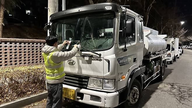 지난달 27일 자정부터 약 1시간30분 동안 광주 북구 문흥동 ‘맥문동 숲길’ 일원에서 ‘사업용자동차 차고지 외 밤샘주차 단속’을 실시한 북구청 교통행정과 직원이 밤샘주차로 적발된 화물차 전면 유리에 ‘위반행위 적발보고서’를 부착하고 있다./윤찬웅 기자