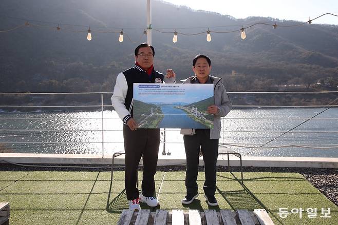 이현재 하남시장(왼쪽)과 주광덕 남양주시장이 올 1월 한강을 가로지르는 친환경 출렁다리 건설에 합의한 뒤 경기 남양주시에서 기념사진을 찍고 있다. 하남시 제공