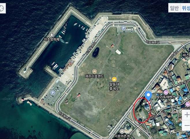 위성 지도로 본 갈등 부지(붉은 원 표시) 주변 현황. 부지 앞쪽으로 4차선 도로와 대규모 매립지(제주이호랜드)가 가로막고 있어, 사구 형성의 필수 요건인 '바다로부터의 모래 공급'이 지리적으로 차단돼 보여진다. 출처 네이버 위성지도.