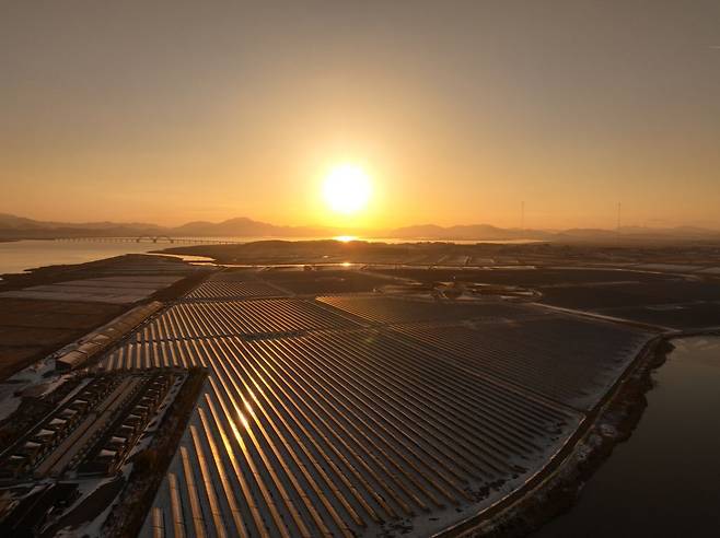 지난달 23일 전남 해남군에 위치한 솔라시도 태양광 발전소 넘어로 붉은 태양이 떠오르고 있다.