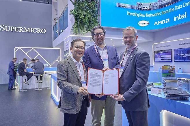 MWC26 슈퍼마이크로 전시관에서 기념 촬영 중인 (왼쪽부터) 하민용 SKT AI DC 사업 담당, 앤드류 브래드너 슈나이더 일렉트릭 수석 부사장, 클레이 시먼스 슈퍼마이크로 부사장의 모습.(사진제공=SK텔레콤)