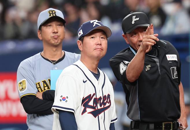 한국 WBC 대표팀 류지현 감독(가운데)이 한신 후지카와 큐지 감독(왼쪽)과 라인업을 교환한 뒤 심판의 설명을 듣고 있다. 사진 | 연합뉴스