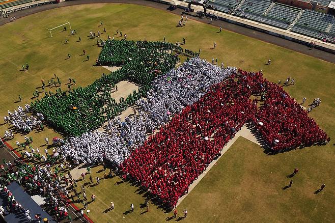 지난달 27일(현지시간) 멕시코 툭스틀라 구티에레스의 빅토르 마누엘 레이나 스타디움에서 사람들이 줄지어 서서 멕시코 축구 대표팀 유니폼 모양을 만들고 있다. 로이터=연합뉴스