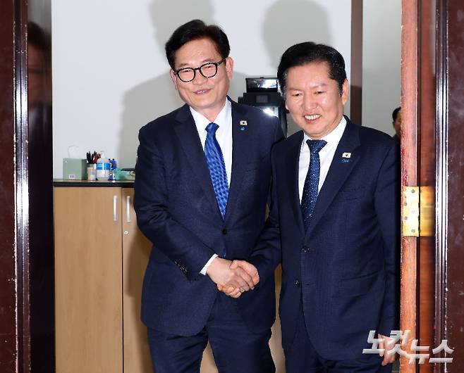 더불어민주당 정청래 대표(오른쪽)와 복당한 송영길 전 대표가 5일 국회 당대표실에서 면담 후 악수하고 있다. 황진환 기자