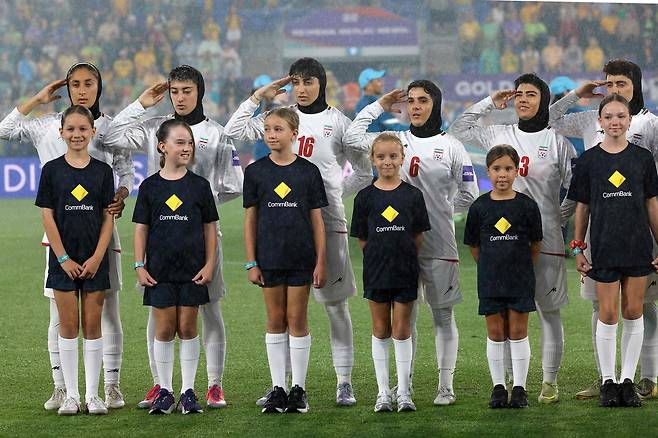 지난 5일 호주 골드코스트에서 열린 2026 아시아축구연맹(AFC) 여자 아시안컵 호주전에 앞서 이란 여자 축구대표팀 선수들이 국가 연주에 맞춰 거수경례를 하고 있다. AFP