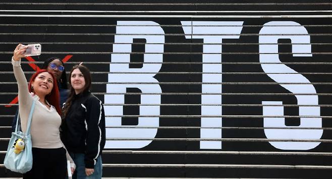 그룹 방탄소년단의 컴백 라이브 공연을 열흘 앞둔 11일 서울 종로구 세종문화회관 계단에 마련된 방탄소년단 공연 홍보물 앞에서 외국인 관광객들이 기념촬영을 하고 있다.(사진=뉴스1)