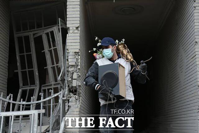 이란 시민이 12일(현지시간) 테헤란의 손상된 건물에서 생필품을 찾고 있다. /테헤란=신화.뉴시스