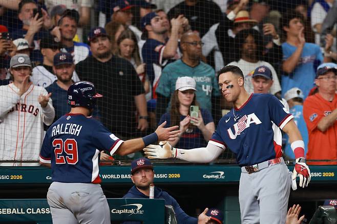 HOUSTON, TEXAS - MARCH 13: Cal Raleigh #29 celebrates his score with Aaron Judge #99 of Team United States during the sixth inning against Team Canada at Daikin Park on March 13, 2026 in Houston, Texas. AFP연합뉴스